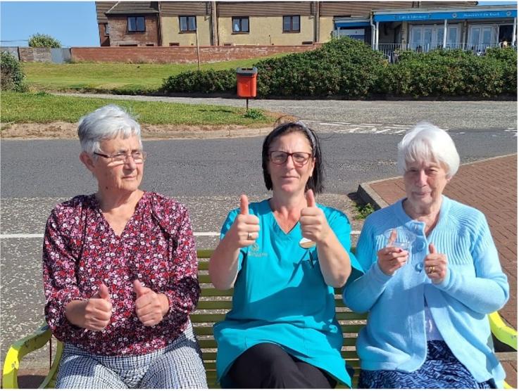 residents-and-care-assistant-thumbs-up