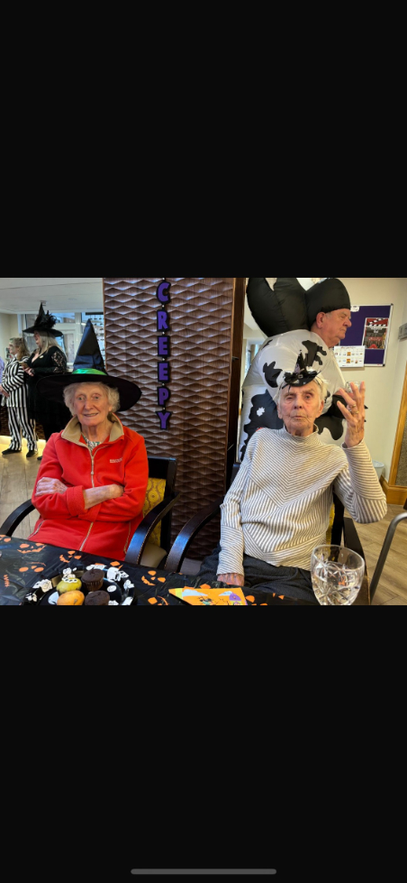 Residents, staff, and visitors dressed in creative Halloween costumes enjoying the party