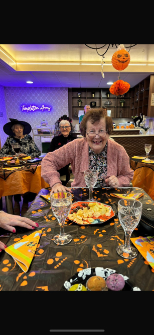 Residents, staff, and visitors dressed in creative Halloween costumes enjoying the party